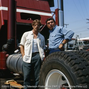 Claude Akins and Frank Converse pose behind a truck