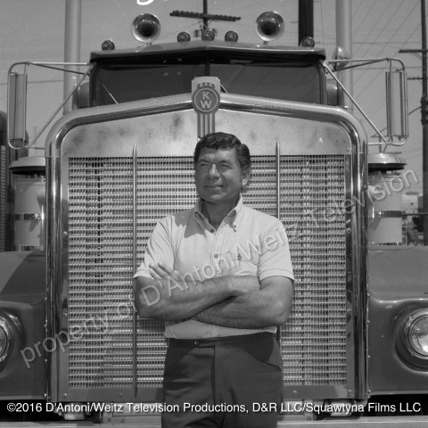 Claude Akins poses in front of In Tandem Kenworth