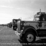 White Star, GMC, and Kenworth tractors lined up to race in Movin' On