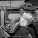 Claude Akins poses beside In Tandem Kenworth