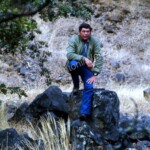 Claude Akins sits on a rock
